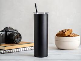 Black Textured Tumbler with Straw Near Camera and Cookies on White Table photo