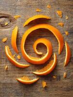 Creative Decorative Orange Peel Spiral on Rustic Wood Surface With Scattered Pieces for Culinary Presentation photo