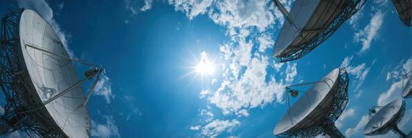 Satellite Dishes Broadcast Signals to Global Audiences Against a Clear Blue Sky With Scattered Clouds photo