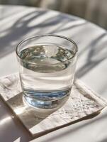 Warm Salt Water Glass Placed on a Coaster Next to an Instruction Card for Gargling During a Calm Morning photo