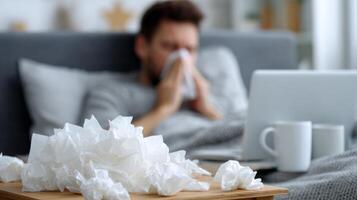 Sick Man Working From Bed Surrounded by Tissues While Trying to Stay Productive photo
