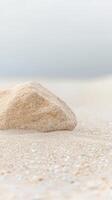 Serene Coastal Landscape A Solitary Natural Stone Rests Peacefully on a Soft, Textured Sandy Beach, Evoking Calmness and Minimalist Beauty. photo