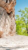 Majestic Rugged Cliff Face with Vibrant Green Foliage Under a Clear Blue Sky, Capturing the Serene Beauty of a Natural Landscape photo
