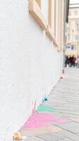 Vibrant Chalk Powder Splashes on a Pristine White Building Wall and Pavement, Capturing Urban Artistic Expression in a Dynamic Street Scene. photo