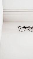 Minimalist Black Eyeglasses on Pristine White Surface photo