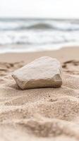 Textured rock resting on golden sand, with gentle ocean waves in the background, evoking a serene coastal landscape. A tranquil beach scene. photo