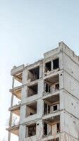 Striking view of an abandoned, dilapidated concrete building against a clear sky, symbolizing urban decay and forgotten structures. photo