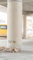 Stark Concrete Pillar with Urban Graffiti and Debris, Evoking Industrial Resilience and City Life Under an Overpass, Featuring Blurry Transport. photo