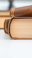 Close-up of a stack of vintage leather-bound books, showcasing aged paper pages and classic scholarly wisdom on a white background. photo