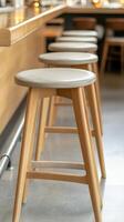 Modern Wooden Bar Stools Lined Along a Sleek Counter in a Contemporary Cafe Interior, Evoking a Serene and Inviting Hospitality Space. photo