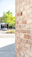 Textured Brick Wall in Warm Sunlight, Revealing Urban Architectural Details and a Softly Blurred Street Scene, Ideal for Backgrounds and Design. photo