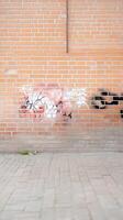 Vibrant street art adorns a textured brick wall, showcasing urban decay and creative expression on a gritty city facade. A compelling visual narrative. photo