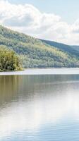 Serene Lake Reflection Amidst Lush Green Hills and Clear Blue Sky. A Tranquil Natural Landscape Vista for Peace and Calm. photo