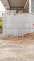 Abstract view of robust concrete bridge support and construction debris, showcasing industrial architecture and raw textures of urban infrastructure. photo