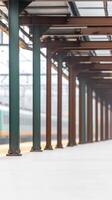 Architectural Perspective of a Train Station Platform with Repeating Pillars and a Distant Train, Evoking Urban Travel and Industrial Elegance photo