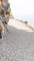 A Serene Gravel Path Winding Along a Rugged Cliff Edge, Inviting Exploration Through Nature's Textured Landscape and Tranquil Vistas. photo