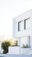 Sleek Modern White Architectural Facade with Clean Lines and Bright Sunlight, Minimalist Contemporary Home Exterior Design. photo