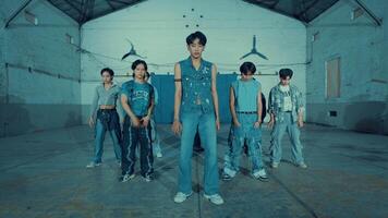 Stylish young group in denim posing in an industrial setting with cool blue lighting. video