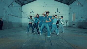 Group of young people practicing dance moves in a warehouse setting. video