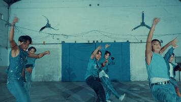 Blurry image of a group of dancers in motion, with a focus on one in the center. video
