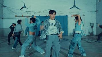 Group of young dancers practicing in an industrial-looking hall, displaying energy and movement video