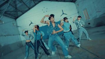 Group of young dancers practicing in an industrial-looking hall, displaying energy video