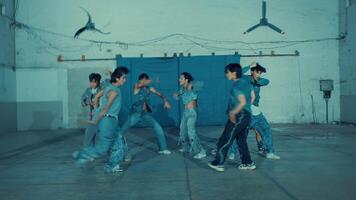 Group of young men in denim dancing in an industrial setting with dynamic poses video