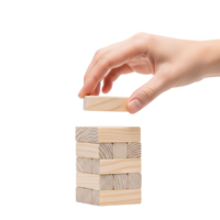 A hand carefully places a wooden block on a tower isolated on transparent background png
