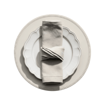 A neatly folded napkin rests on a decorative plate, isolated on transparent background, creating an elegant table setting png