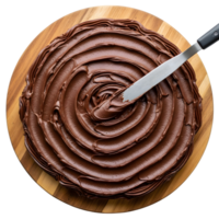 Chocolate cake is being frosted with a metal spatula on a wooden board png
