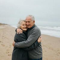 Affectionate Senior Couple Embracing on a Coastal Beach Under Overcast Sky photo