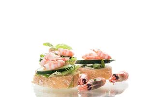 Delicious portioned appetizers with shrimps and greens on a white background photo
