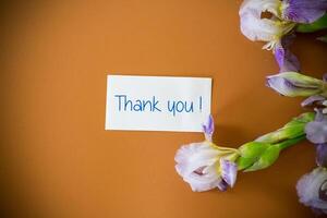 Fresh cut irises with bright greenery on a brown background . photo