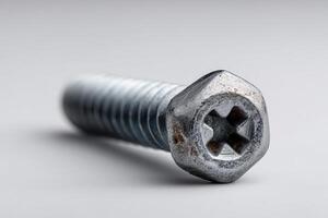 Close up of a shiny screw on grey background photo