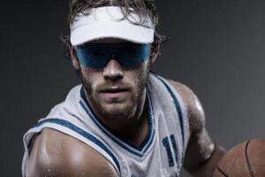 Sweaty basketball player with visor holds ball photo