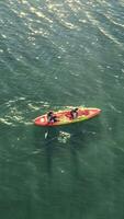 Aerial view Sports recreation on a large lake. Two people on one duck swim on the lake. video