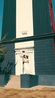 Happy couple in love standing near a small building in the field. A cozy place for two people. Sunny bright day and two lovers together. video