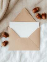 Elegant greeting card and envelope mockup with acorns on cozy fabric background photo