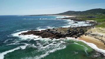 This stunning beach scene showcases rocky shores, lush greenery, and the soothing sound of ocean waves photo