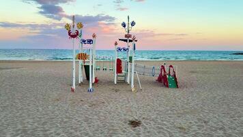 A vibrant and lively beach playground showcasing imaginative designs, all set against a breathtaking sunset backdrop photo