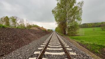 A breathtaking scenic view of railway tracks intricately weaving through lush, vibrant greenery beneath a cloudy sky photo