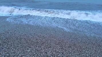 Gorgeous waves gently rolling onto a picturesque pebble beach, beautifully capturing the essence of nature at dusk photo