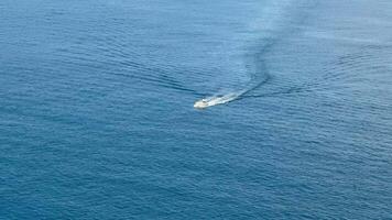 An aerial shot capturing a boat's wake on serene blue waters, showcasing marine serenity and adventure. photo