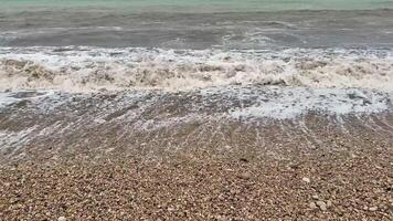Gentle waves rhythmically crashing upon a lovely pebble beach, beautifully showcasing natures serene allure and charm photo