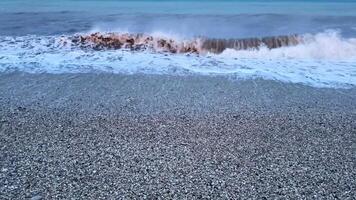 Immerse yourself in the serene and captivating beauty of gentle waves crashing against a pebbled beach during twilight photo