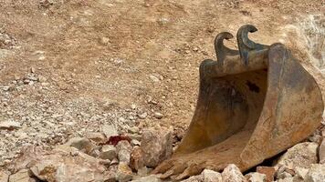 A thorough and detailed view of an excavation site showcasing heavy machinery alongside various rock formations photo
