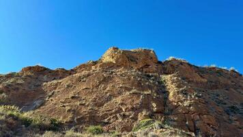 A breathtaking view showcasing impressive rocky formations alongside lush greenery beneath a clear blue sky photo