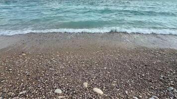 A beautifully calm beach scene that showcases the soft waves gently lapping against a pebblestrewn shore photo