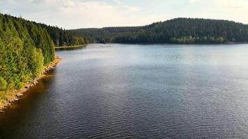 A tranquil lake beautifully reflecting natures stunning beauty, with dense forests gracefully lining the shore photo