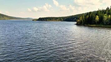 A peaceful and serene lake scene featuring gentle waves, vibrant trees, along with a stunning, picturesque sky photo